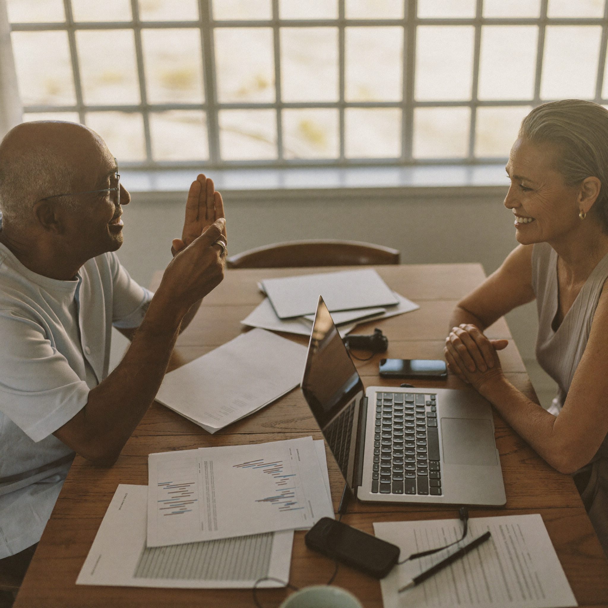 A couple in conversation with an Elvaris & Co advisor at their kitchen table
